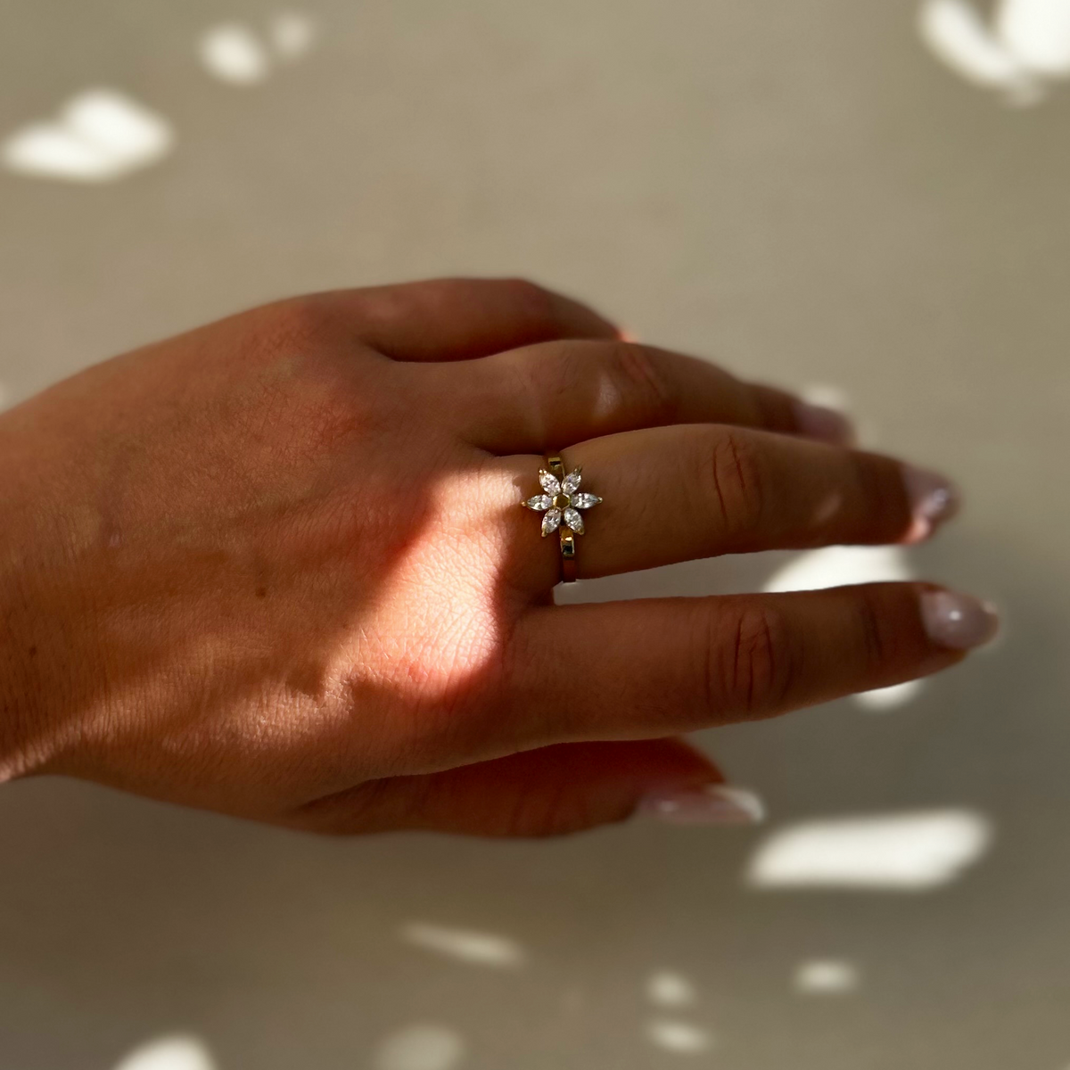 Bague Selena ajustable avec fleur aux pétales strassés portée au doigt - L'atelier de Julia
