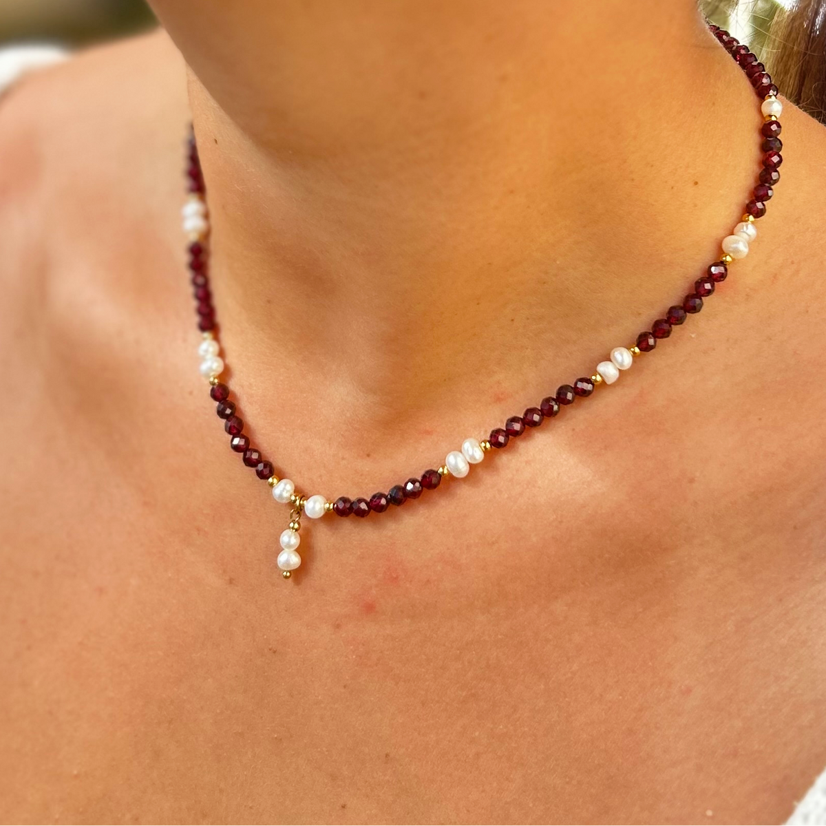 Collier Adèle en grenat rouge, gros plan porté au cou - L'atelier de Julia